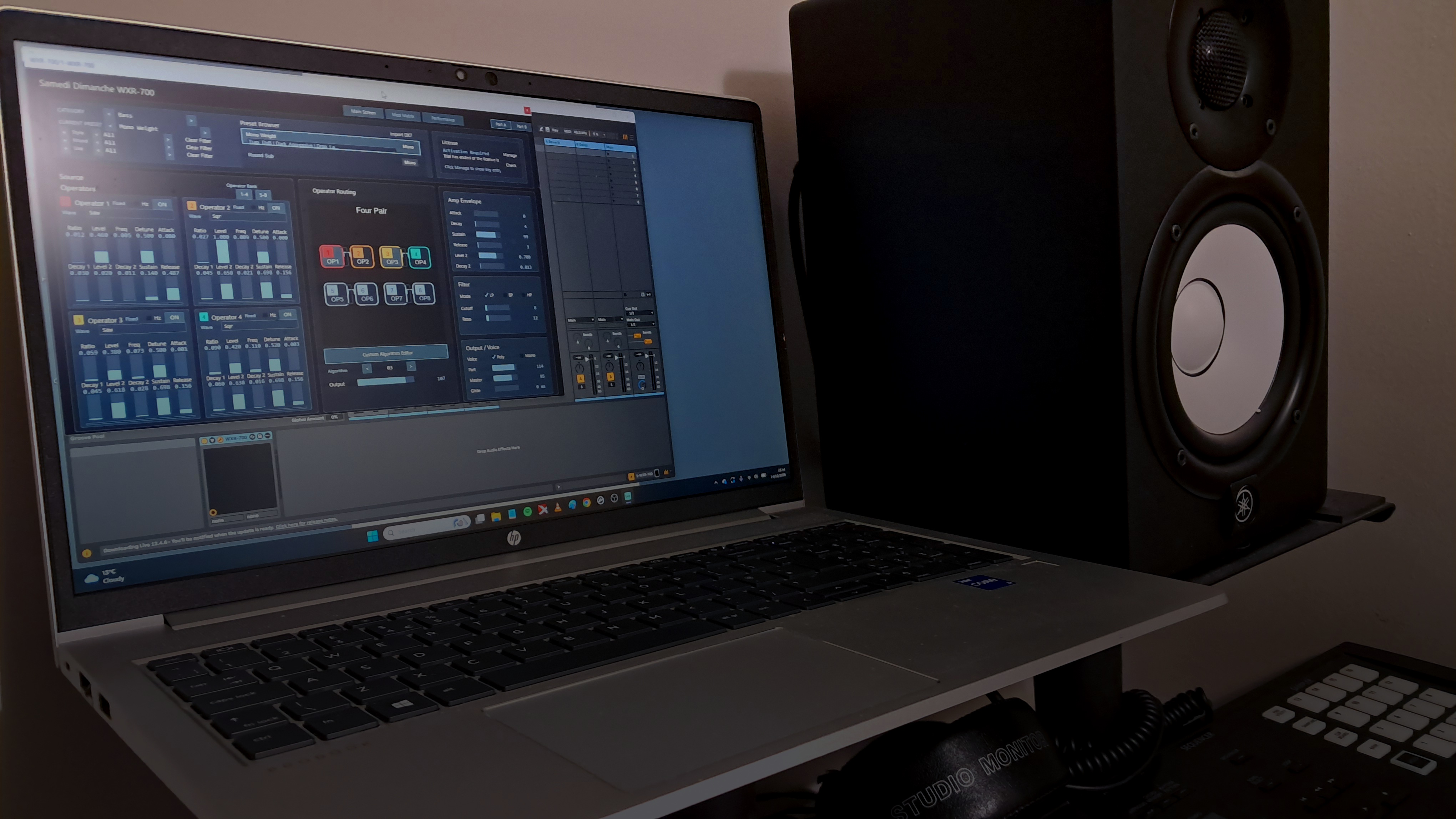A laptop on a desk beside a studio monitor, running the WXR-700 plugin.